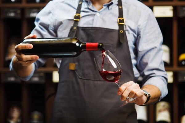 Male,Sommelier,Pouring,Red,Wine,Into,Long-stemmed,Wineglasses. vin